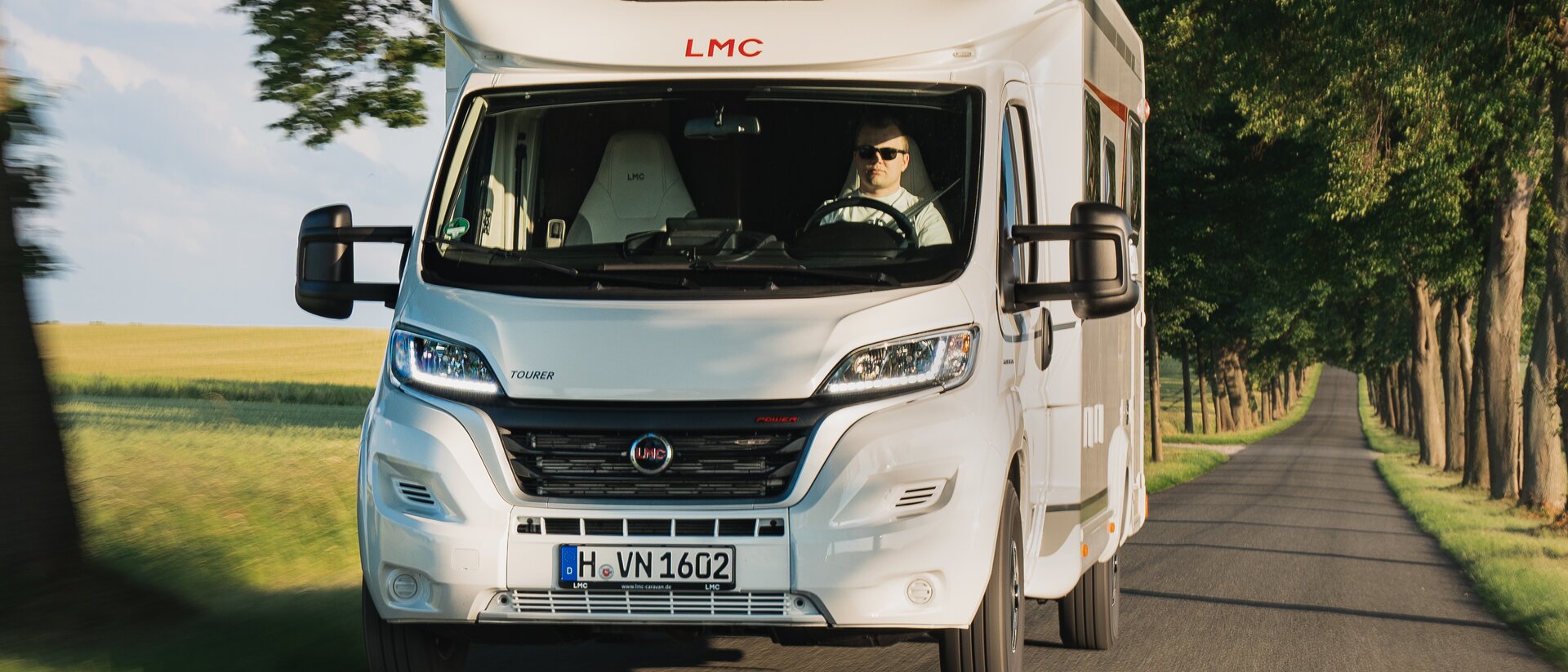 LMC Wohnmobil auf Landstraße mit Fahrer