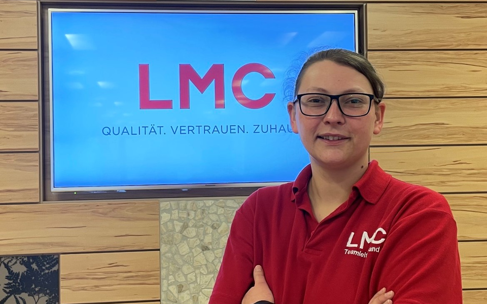 LMC Mitarbeiterin Hannah Weiss vor LMC Logo