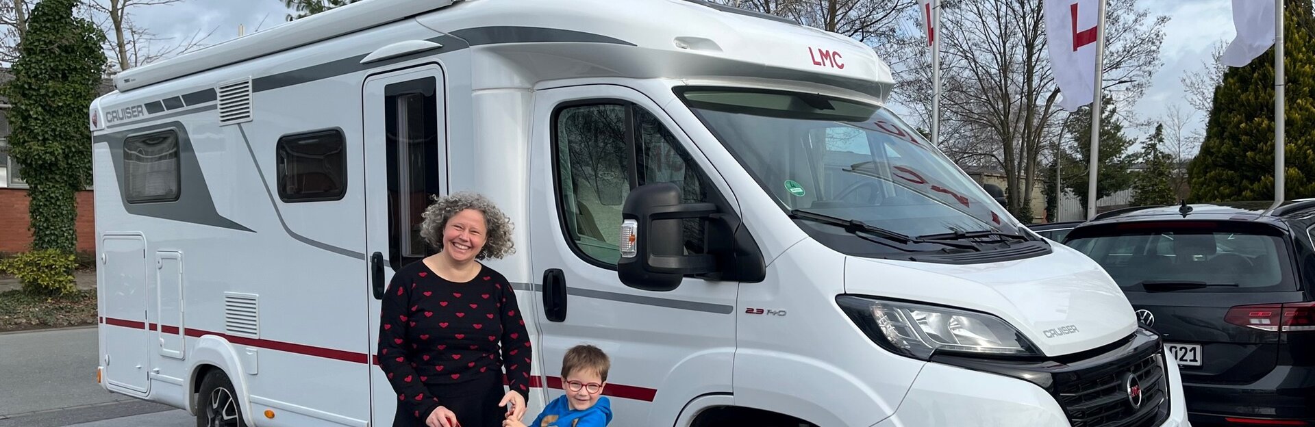 Frau mit Kind und Blindenstock vor LMC Camper