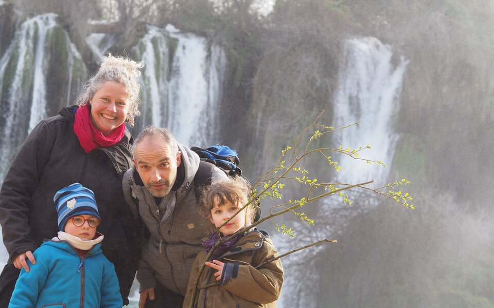 Familie mit zwei Kindern, Wasserfall im Hintergrund