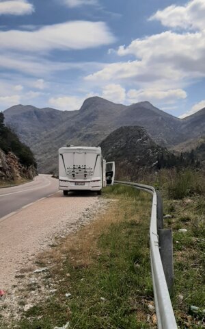 LMC Camper Rückansicht auf Straße, im Hintergrund Gebirge