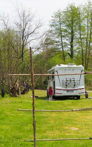 Kind auf Wiese vor LMC Wohnwagen