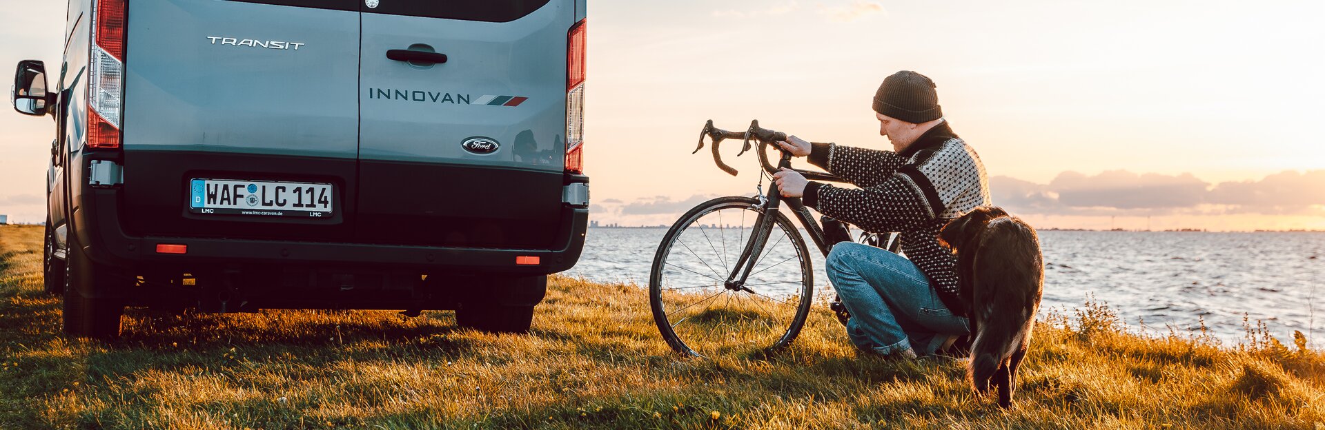 Mann mit Hund und Fahrrad vor LMC Innovan sitzend