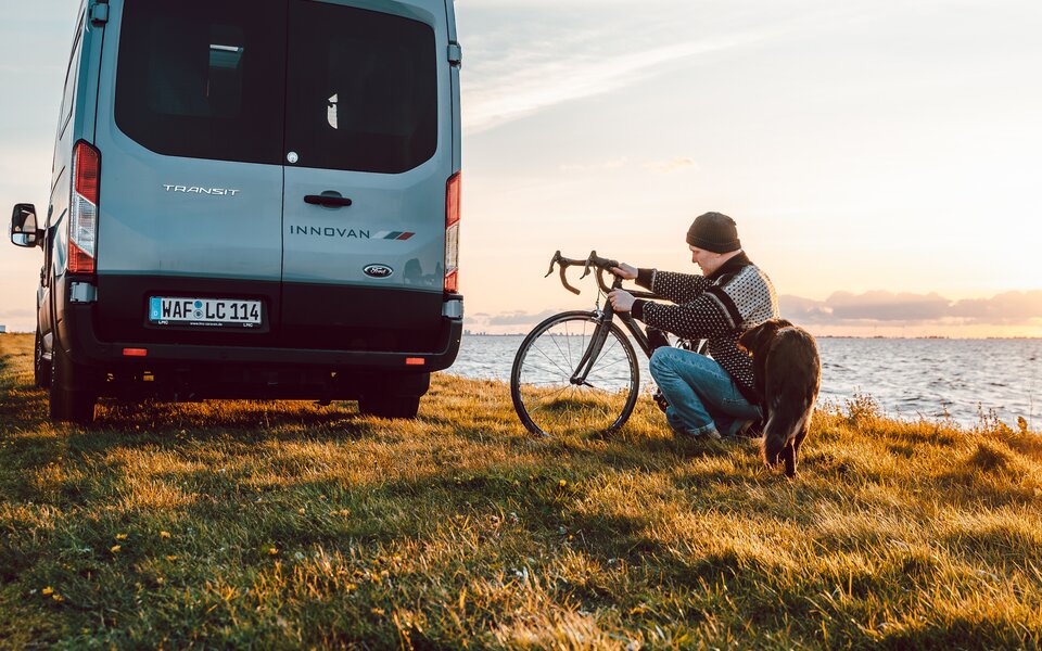Mann mit Hund und Fahrrad vor LMC Innovan sitzend