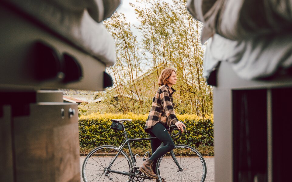 Blick durch Heckklappe auf Frau mit Fahrrad 