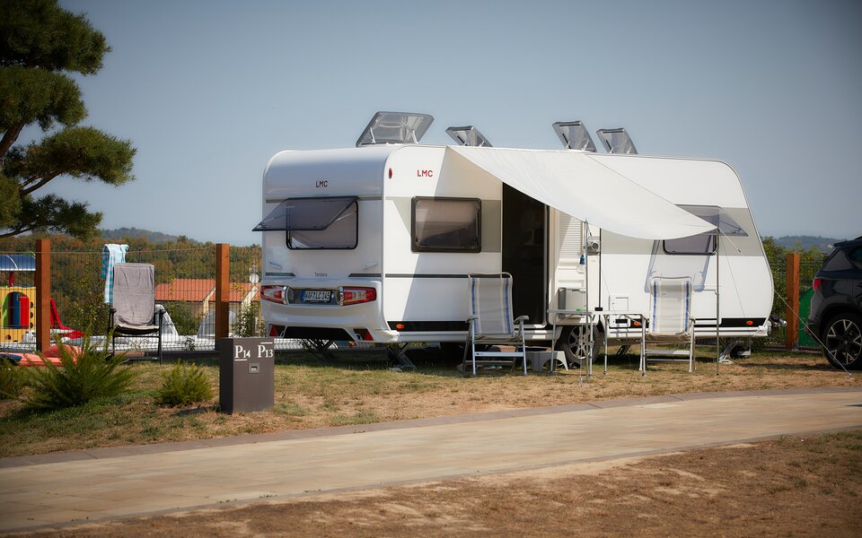 Offener LMC Wohnwagen auf Campingplatz mit Campingstühlen