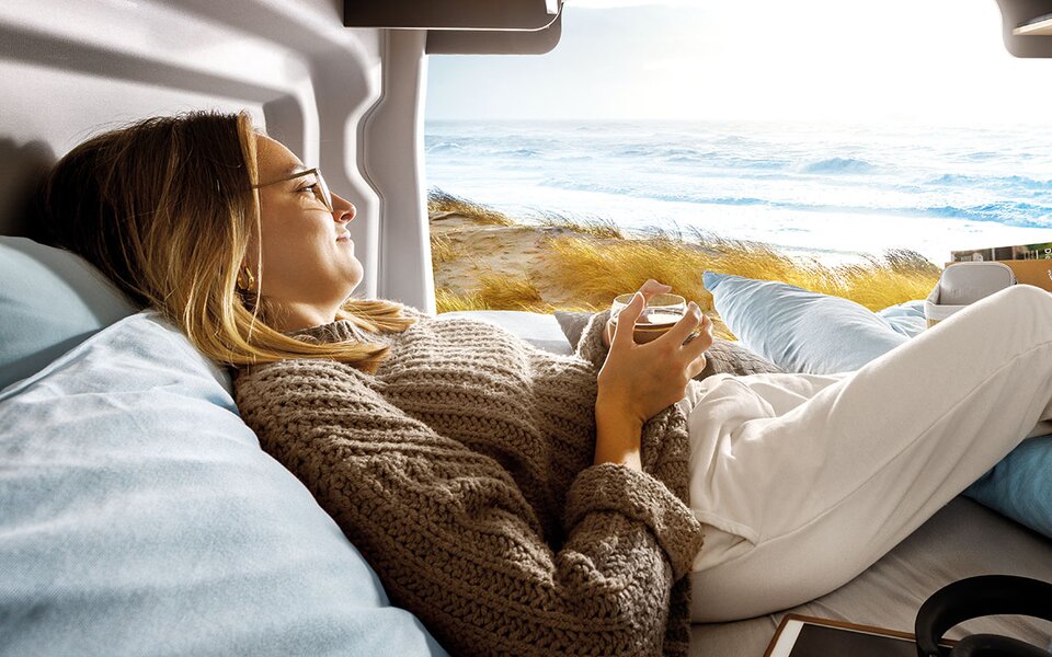 Frau in Campingfahrzeug am Meer