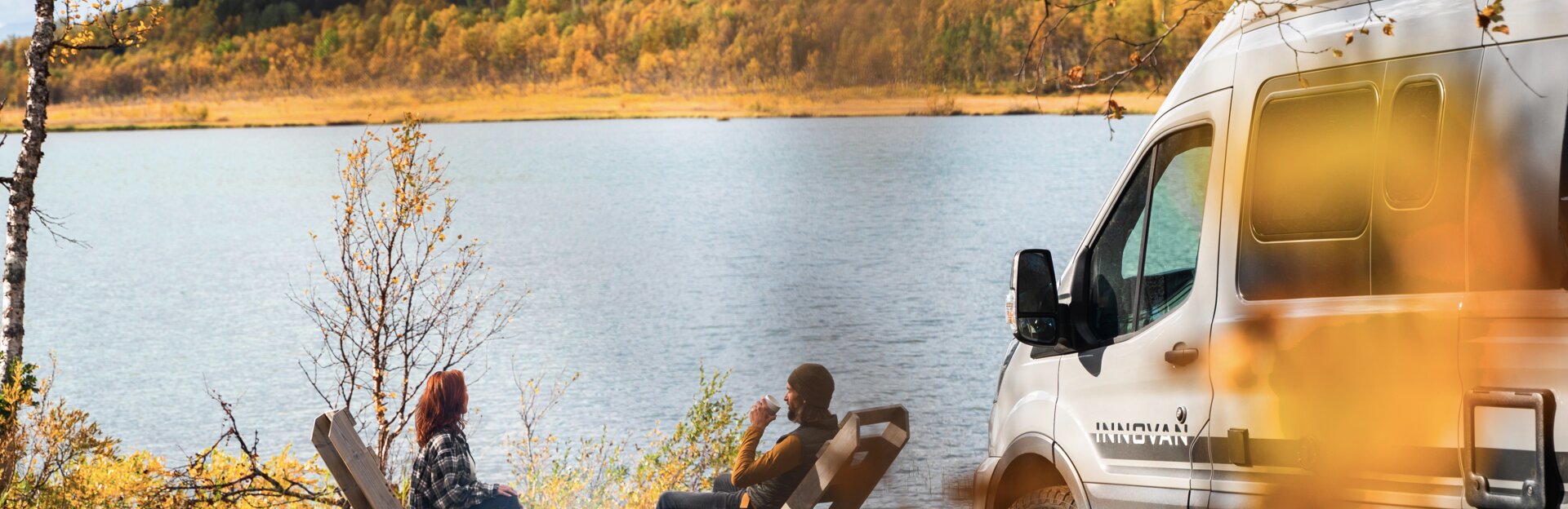Mann und Frau am See mit LMC Innovan im Bild; Landschaft in herbstlichen Farben