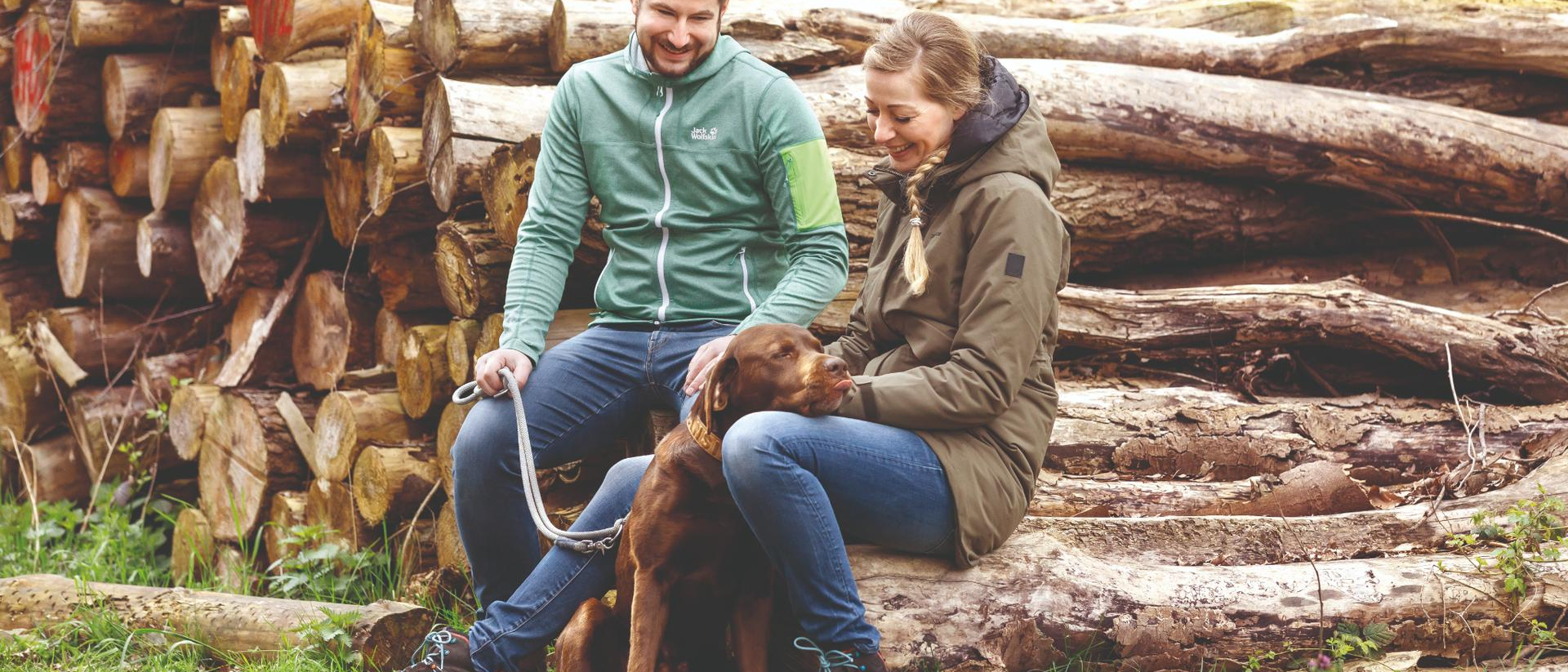 Paar mit Hund auf dem Campingplatz im Wald