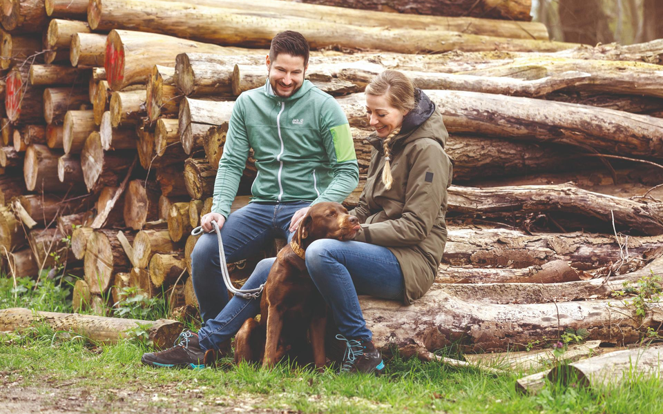 Couple with dog at the campsite in the forest