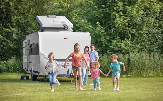 Familie mit 4 Kindern auf Campingplatz mit Wohnwagen LMC Vivo