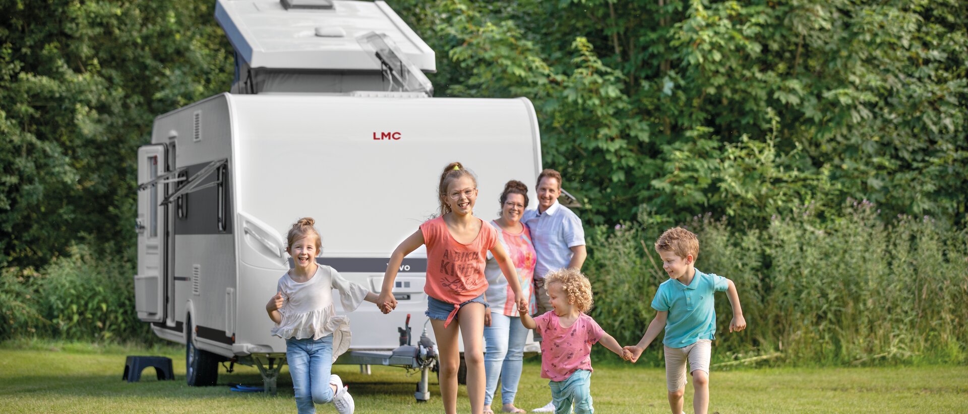 Familie mit 4 Kindern auf Campingplatz mit Wohnwagen LMC Vivo