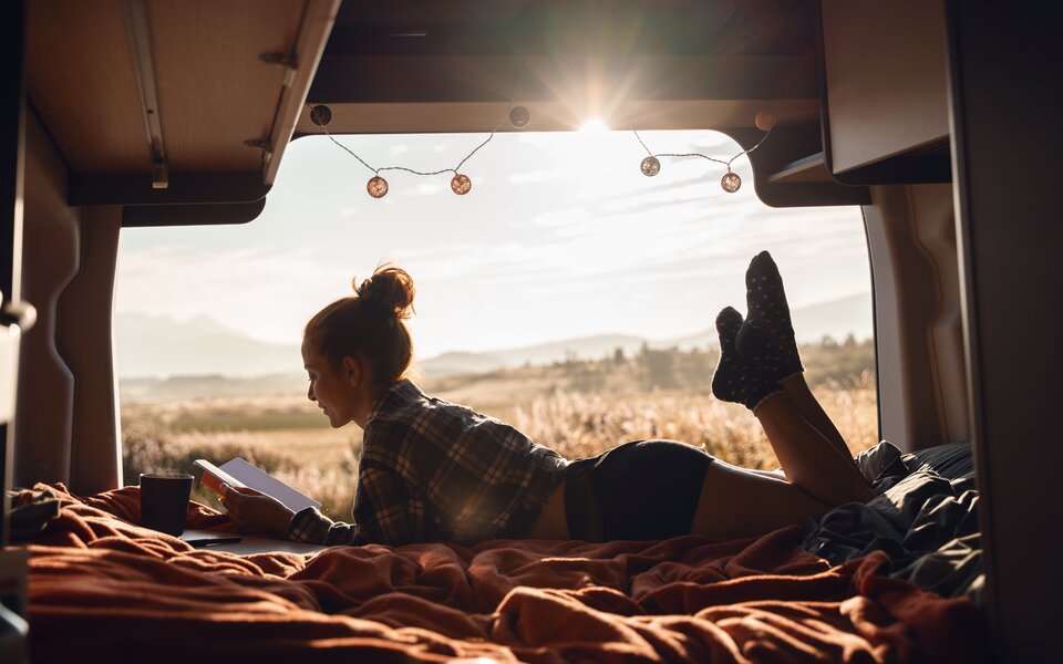 Eine Frau liegt im Bett des LMC Innovans und ließt ein Buch